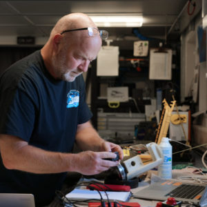 Deep sea biologist Tim Shank changes the settings on a camera that the team has been using to photograph deep-sea corals. The camera is placed in a pressure resistant housing capable of going to thousands of meters in the deep ocean.